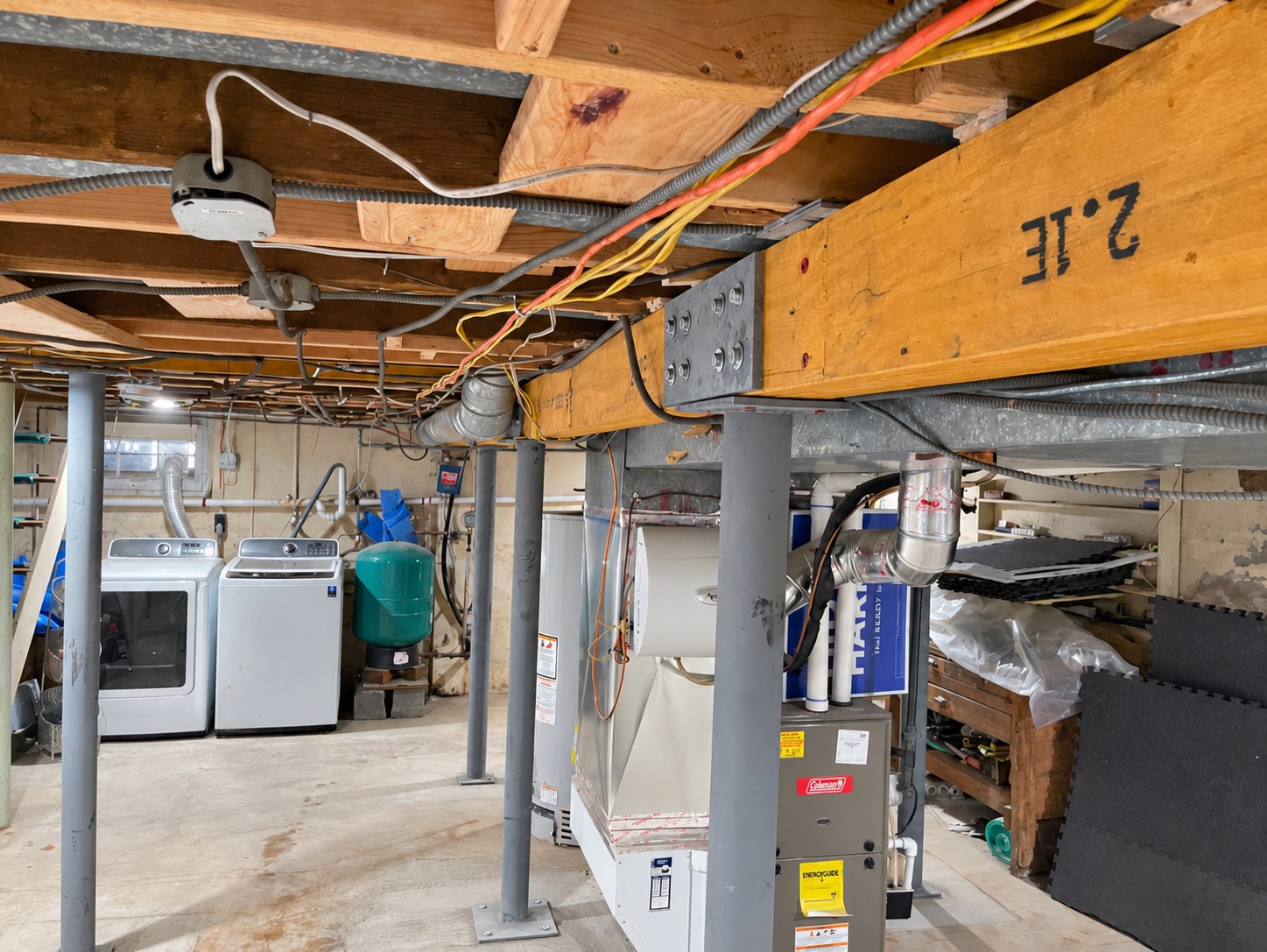 Wood beam connection hardware and steel support columns in a basement